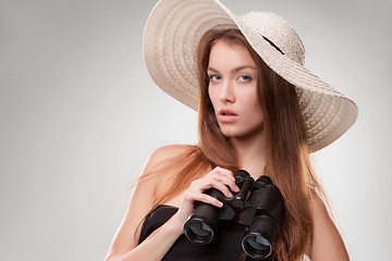 Image showing Young woman in hat with binoculars