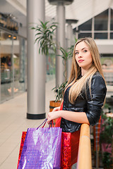 Image showing beautiful young woman with a shopping bags in the mall