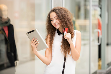 Image showing Beautiful young girl paying by credit card for shopping 