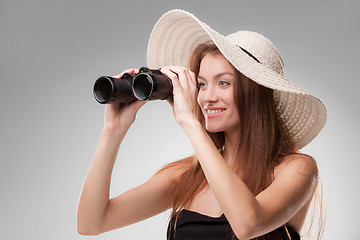 Image showing Young woman in hat with binoculars