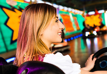 Image showing Beautiful girl in an electric bumper car in amusement park