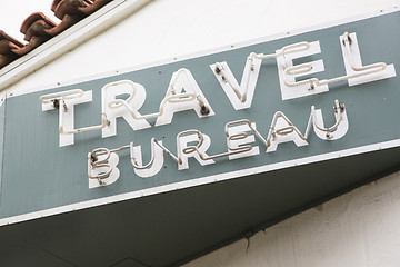 Image showing Neon Travel Bureau Sign on Building