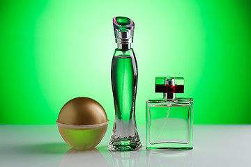 Image showing Three perfume bottle on a bright green background