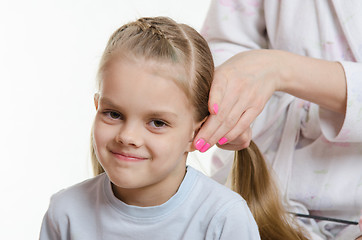 Image showing Mom braids tails of hair six-year daughter