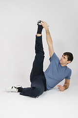 Image showing Athlete stretches muscles of legs by raising