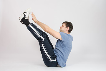 Image showing Athlete stretching his arms raised to the feet