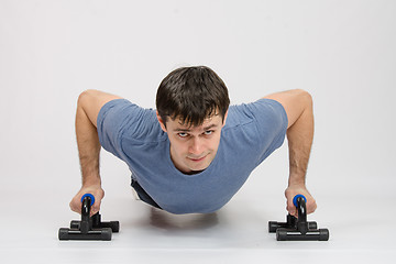 Image showing The athlete performs a bench on supports