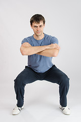 Image showing young man performs squats