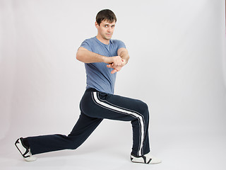 Image showing Young man in sportswear warming up