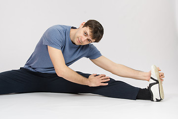 Image showing Athlete stretches the muscles of left leg