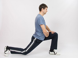 Image showing The athlete performs stretching using squats