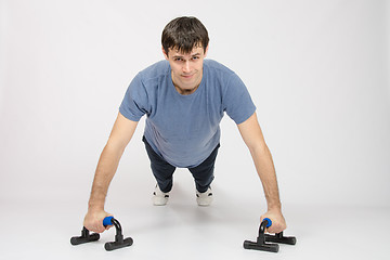 Image showing Athlete the highest point at push-ups on legs