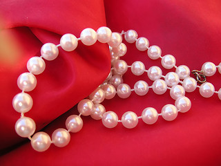 Image showing pearls on red cushion