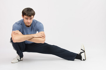 Image showing Sportsman squatting muscles pulling the left foot