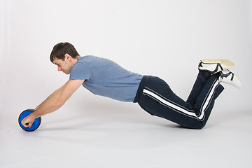 Image showing Athletes perform push-ups with the wheel