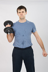 Image showing athlete with a dumbbell effort raises his right hand