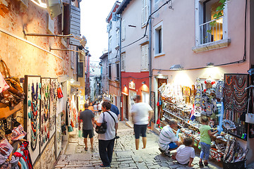 Image showing Tourists walking next to displayed souvenirs in Rovinj