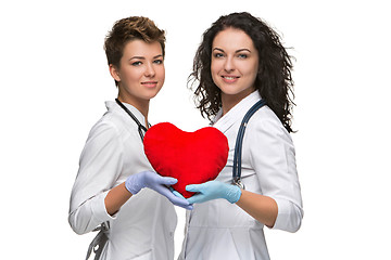 Image showing Two woman doctor holding a red heart