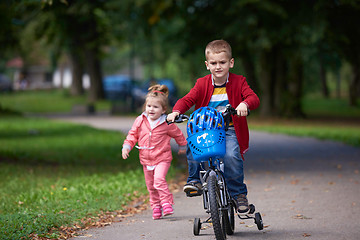 Image showing boy and girl with bicycle