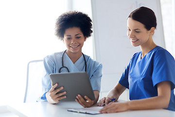 Image showing happy doctors with tablet pc meeting at hospital