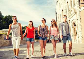 Image showing group of smiling friends walking in city