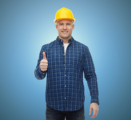 Image showing smiling male builder in helmet showing thumbs up