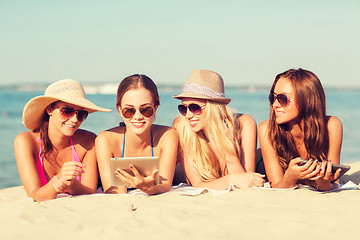 Image showing group of smiling young women with tablets on beach