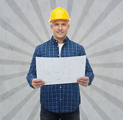 Image showing smiling male builder in helmet with blueprint