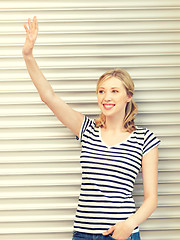 Image showing happy teenage girl waving a greeting