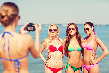 Image showing group of smiling women photographing on beach