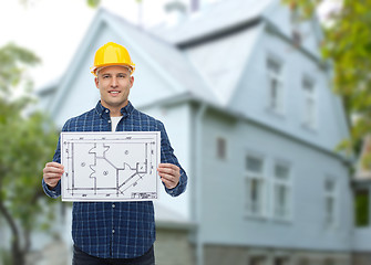 Image showing smiling builder with blueprint over house