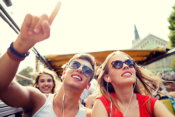 Image showing smiling couple with earphones traveling by bus