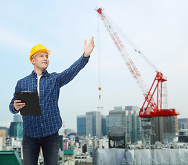 Image showing smiling male builder in helmet with clipboard