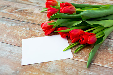 Image showing close up of red tulips and blank paper or letter