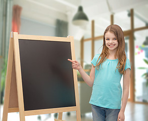 Image showing happy little girl with blackboard and chalk