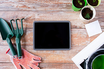 Image showing close up of tablet pc and garden tools on table