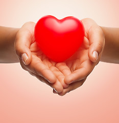 Image showing close up of female hands holding small red heart