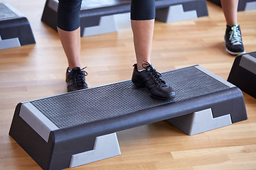 Image showing close up of women exercising with steppers in gym