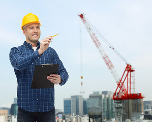 Image showing smiling male builder in helmet with clipboard