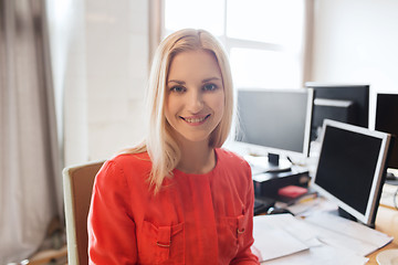 Image showing happy creative female office worker with computers