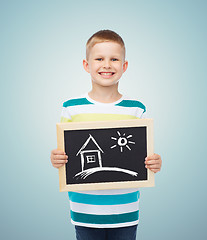 Image showing happy little boy holding chalkboard with home