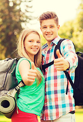 Image showing smiling couple with backpacks showing thumbs up