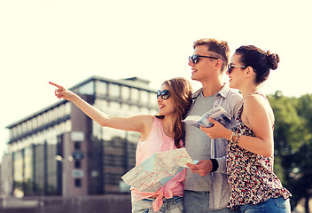 Image showing smiling friends with map and city guide outdoors