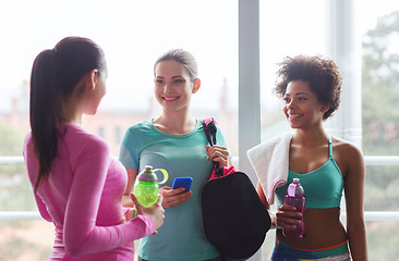 Image showing happy women with bottles of water in gym