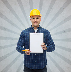 Image showing smiling male builder in helmet with clipboard