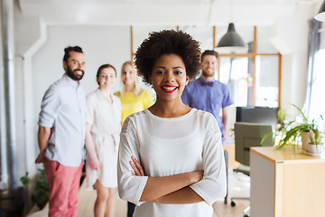 Image showing happy young woman over creative team in office