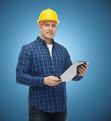 Image showing smiling male builder in helmet with clipboard