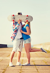 Image showing couple with skateboard kissing outdoors