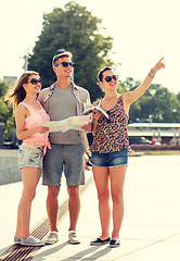 Image showing smiling friends with map and city guide outdoors