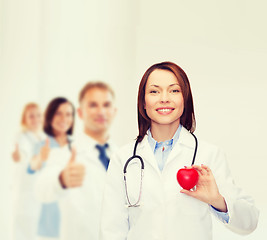 Image showing smiling female doctor with heart and stethoscope